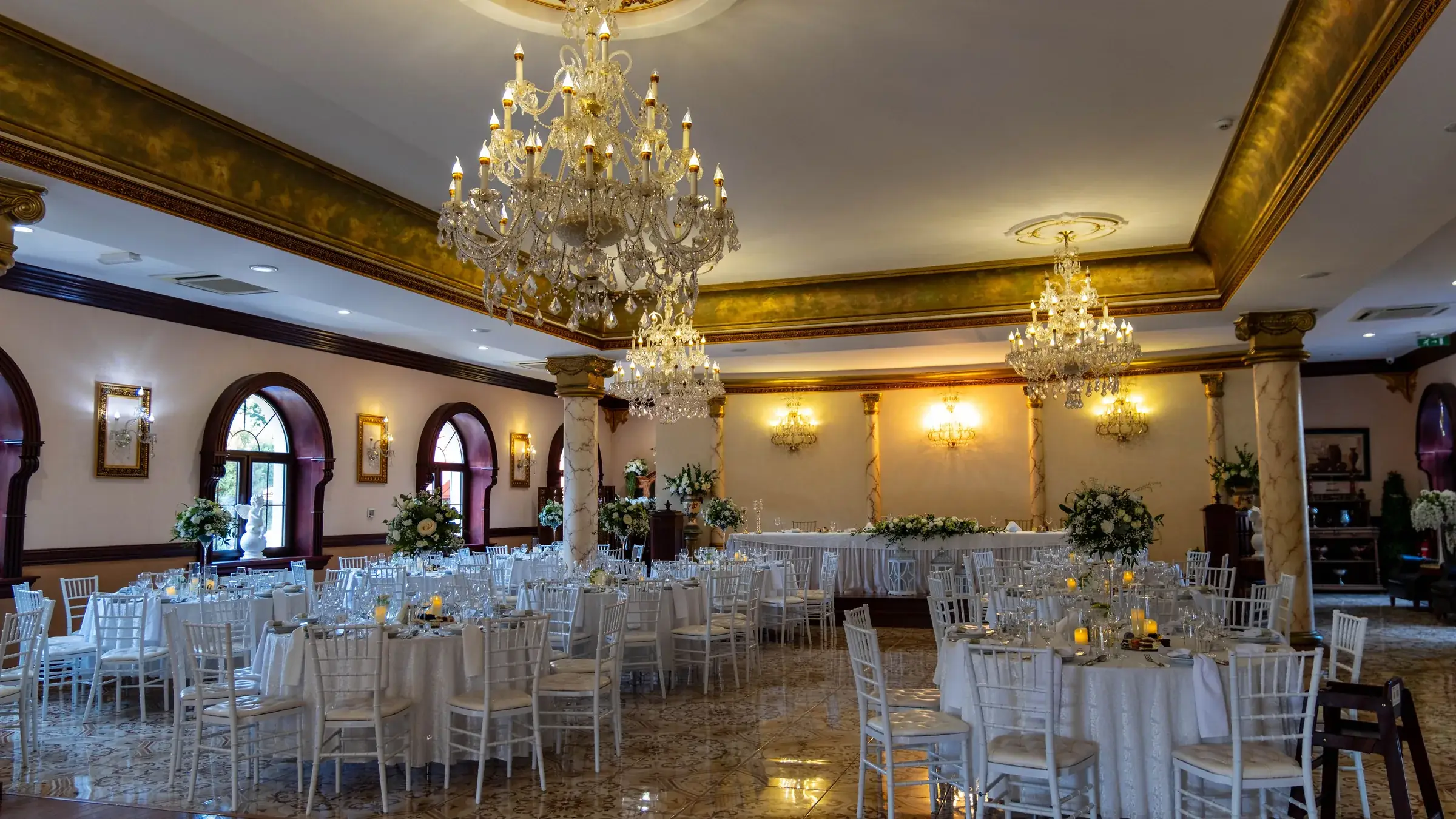 Veľká sála Renesance Restaurant vyzdobená na svadobnú hostinu, krištáľové lustre a slávnostné tabule