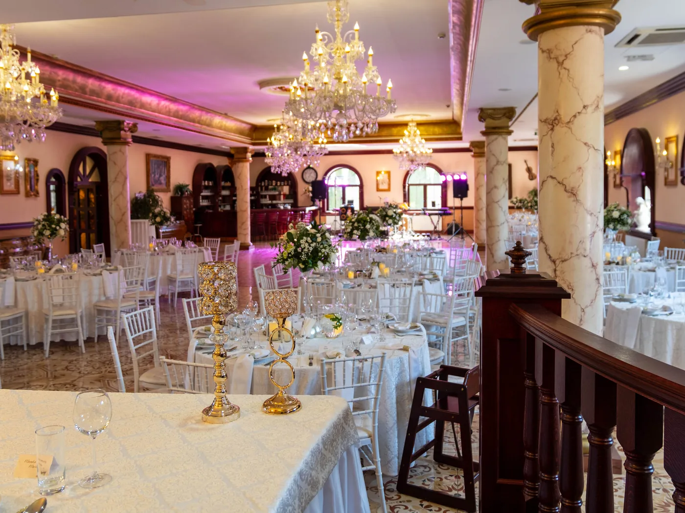 Veľká sála vyzdobená na svadbu, krištáľové lustre a stoličky Chiavari